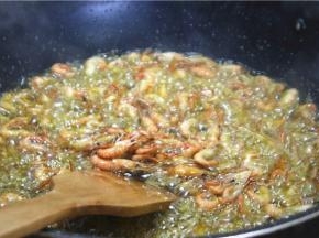 倒入河虾快速炸香，但不要炸太干。炸虾的时候油温一定要烧足够热，油温不够会把油吸进虾里，油温够就不会出现这样的问题。另外，如果炸的虾用量比较多，也可以分批次油炸，以免全部下锅受热不均油炸不好。