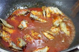 将煎好的带鱼倒入红汤中，加一勺生抽和适量的盐调味，转大火收汁