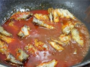 将煎好的带鱼倒入红汤中，加一勺生抽和适量的盐调味，转大火收汁