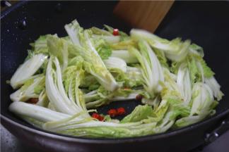 下入娃娃菜翻炒，娃娃菜煸炒至八成熟，微微变软