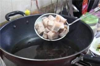 锅内倒油，炸肉的油量不要超过油锅的三分之二，防止迸溅，油温烧至微微冒烟，放入五花肉