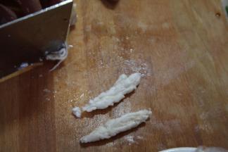 肥肠煮好之后捞出，放到冷水下冲洗浮沫，然后将肥肠从中间剖开，去掉肥油，切成小块