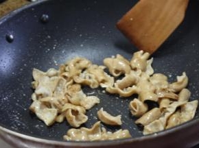 锅内重新倒油，油热之后放入肥肠，大火炒香，炒干水分