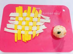 将切好的蛋黄皮和蛋清皮交叉编织，米饭做成小球状