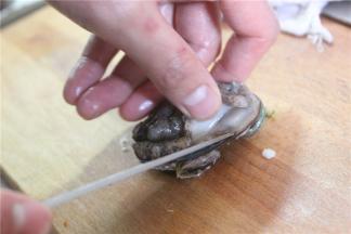 用刀紧贴着壳边，将鲍鱼肉从壳子里剔除来，去掉鲍鱼黄等内脏杂物，切掉鲍鱼的裙边