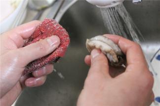 然后用清洁布将鲍鱼缝隙仔细的清洗干净，用刷子将鲍鱼壳清洗干净，留着一会装盘用