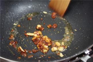 锅内留底油，放入蒜瓣爆香，然后加入1小勺豆瓣酱和辣椒面翻炒出香味