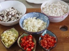 将配料杏鲍菇，冬笋，五花肉，香菇，红椒和姜蒜分别切成丁