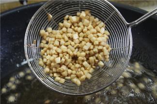 然后七成油温时下分别把杏鲍菇丁，冬笋丁，五花肉丁、香菇丁水分炸干，然后捞起来把油沥掉。