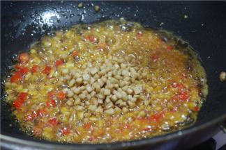 另锅内留少许油，加少许辣椒油，下入炸好的肉丁、杏鲍菇丁、冬笋、香菇丁