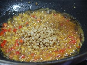 另锅内留少许油，加少许辣椒油，下入炸好的肉丁、杏鲍菇丁、冬笋、香菇丁