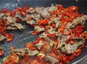 倒入美极鲜和辣鲜露，放入牛肉翻炒均匀
