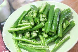 二荆条洗净从中间对剖，炒出来更加好看，辣椒可以卷起来配合肉的形状，同时还方便去籽