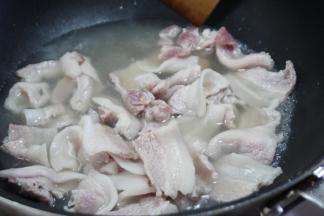 五花肉切成薄片之后放入温水锅内煮至沸腾，捞出控干水分。焯水是为了逼出多余的油脂，吃起来的口感没有那么油腻，同时还可以去除部分腥味