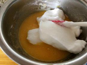 取三分之一蛋白糊加入蛋黄糊中，切拌均匀，从一点钟方向切向7点钟方向，边拌边转动盆子