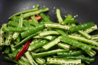 锅内重新倒油，油热之后倒入辣椒，大火翻炒，不断的按压，炒出辣味