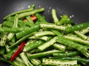 锅内重新倒油，油热之后倒入辣椒，大火翻炒，不断的按压，炒出辣味