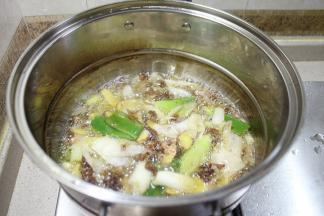 把炒好的油倒入另一个大锅，加入高汤（如没高汤就加入白水）