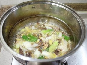 把炒好的油倒入另一个大锅，加入高汤（如没高汤就加入白水）