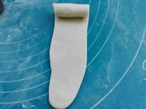 再次重复上述卷法，擀成长椭圆形，自上而下卷好