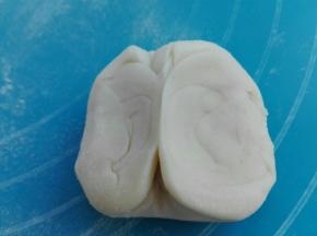 卷好的剂子，两头向中间挤压