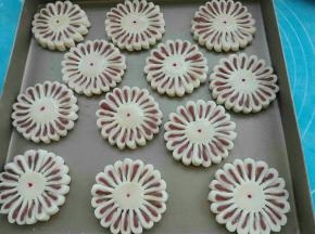 依次切好扭转，菊花酥就成形了，中间刷蛋液，用牙签沾色素点个点装饰一下