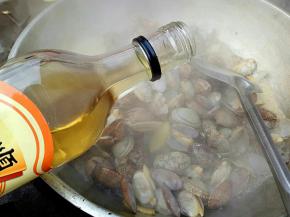 然后放入花蛤翻炒，加入适量料酒去腥