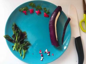 女孩荡秋千的绳子用茄子皮，薄薄切下一长条，剪刀剪成两个细条。