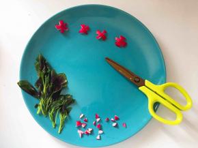 用剪刀随意把红萝卜皮剪成小花！即使剪成个四不像也没关系，反正也就是玩玩嘛！剪掉的碎萝卜我决定就放在盘角做装饰。