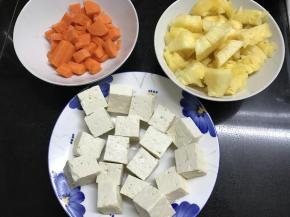 1、胡萝卜和菠萝切成丁，豆腐切成小块。