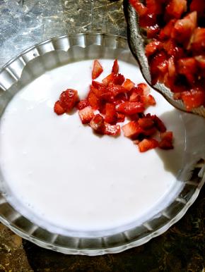 切块的草莓倒入搅拌好的酸奶里