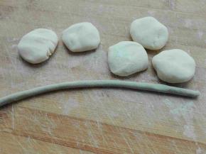 白色面团均分成包饺子用的小剂子，绿色面团搓成细长条