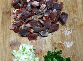 腊肠用开水烫洗一下切丁，蒜头和香葱切碎。