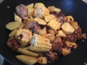 将玉米和土豆倒入锅内翻炒一分钟