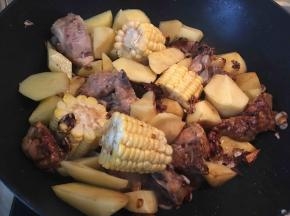 将玉米和土豆倒入锅内翻炒一分钟