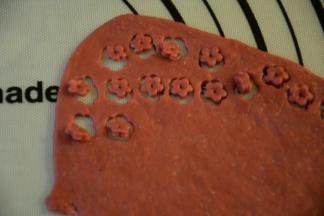 红色面团擀成薄片，模具压出花朵形状。