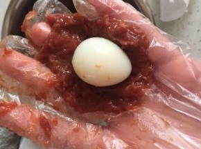 5:取出入味的牛肉，称20克按扁成圆，包入鹌鹑蛋