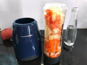2、把切成小块的水果放入料理杯中，加入约200毫升纯净水。