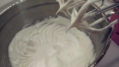 往蛋白中分3次加入糖粉，打至中性发泡。（首先，用打蛋器低速将蛋白搅打至起鱼眼泡，加入1/3的糖粉。接着，继续用电动打蛋器高速搅打，至蛋白体积膨胀1倍，再加入1/3的糖粉。然后，继续用电动打蛋器中速搅打，稍微出现纹路，加入剩余的1/3的糖粉。最后低速搅打，直到提起打蛋器时出现小弯钩即可。）