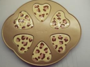 接着分别用红色面糊和可可面糊在蛋糕表面画出豹纹，记得不要画得太均匀。