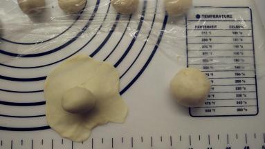 .取一份油皮，用擀面杖擀成圆形，在中间放上一份油酥，像包包子一样包好，收口记得捏紧。