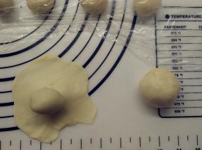 .取一份油皮，用擀面杖擀成圆形，在中间放上一份油酥，像包包子一样包好，收口记得捏紧。