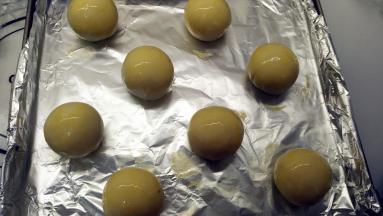 全部处理好的面团放在烤盘上，刷上一层蛋黄液。