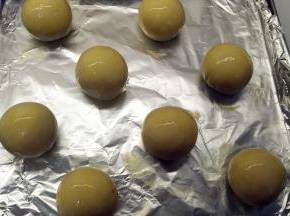 全部处理好的面团放在烤盘上，刷上一层蛋黄液。