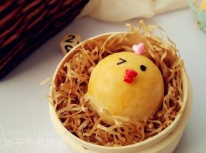 出炉晾凉之后的蛋黄酥用糖片装饰，我用心型糖片做小鸡头饰，圆形糖片剪成两小块之后用巧克力沾上做小鸡嘴巴。最后用色素笔或者巧克力画上眼睛即可。