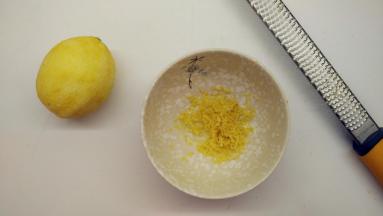 柠檬用盐搓洗干净之后，用刀擦出半个柠檬皮屑。