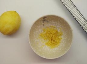 柠檬用盐搓洗干净之后，用刀擦出半个柠檬皮屑。