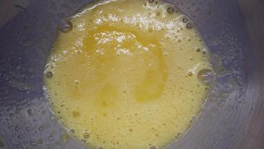 将鸡蛋打散，加入牛奶和柠檬皮屑以及糖粉的混合物，用手动打蛋器将它们搅打均匀。