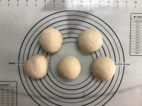 取出面团，排气后均分成5份，滚圆后盖上保鲜膜松弛15分钟。