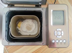 主配方中所有的材料放入面包桶中，酵母放面粉上，黄油放一侧角落，启动面包机和面28分钟